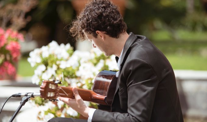 acoustic guitarist performing in a garden