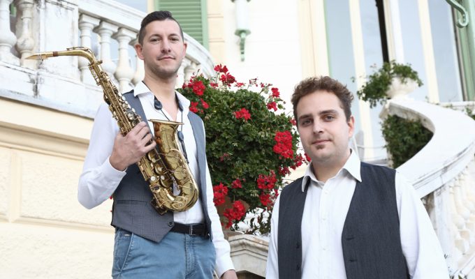 saxophonist and pianist posing on a stair