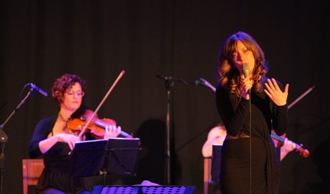 female singer and string quartet performing live