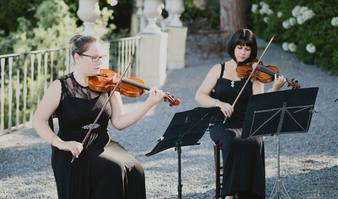 female violinists playing at a wedding ceremony